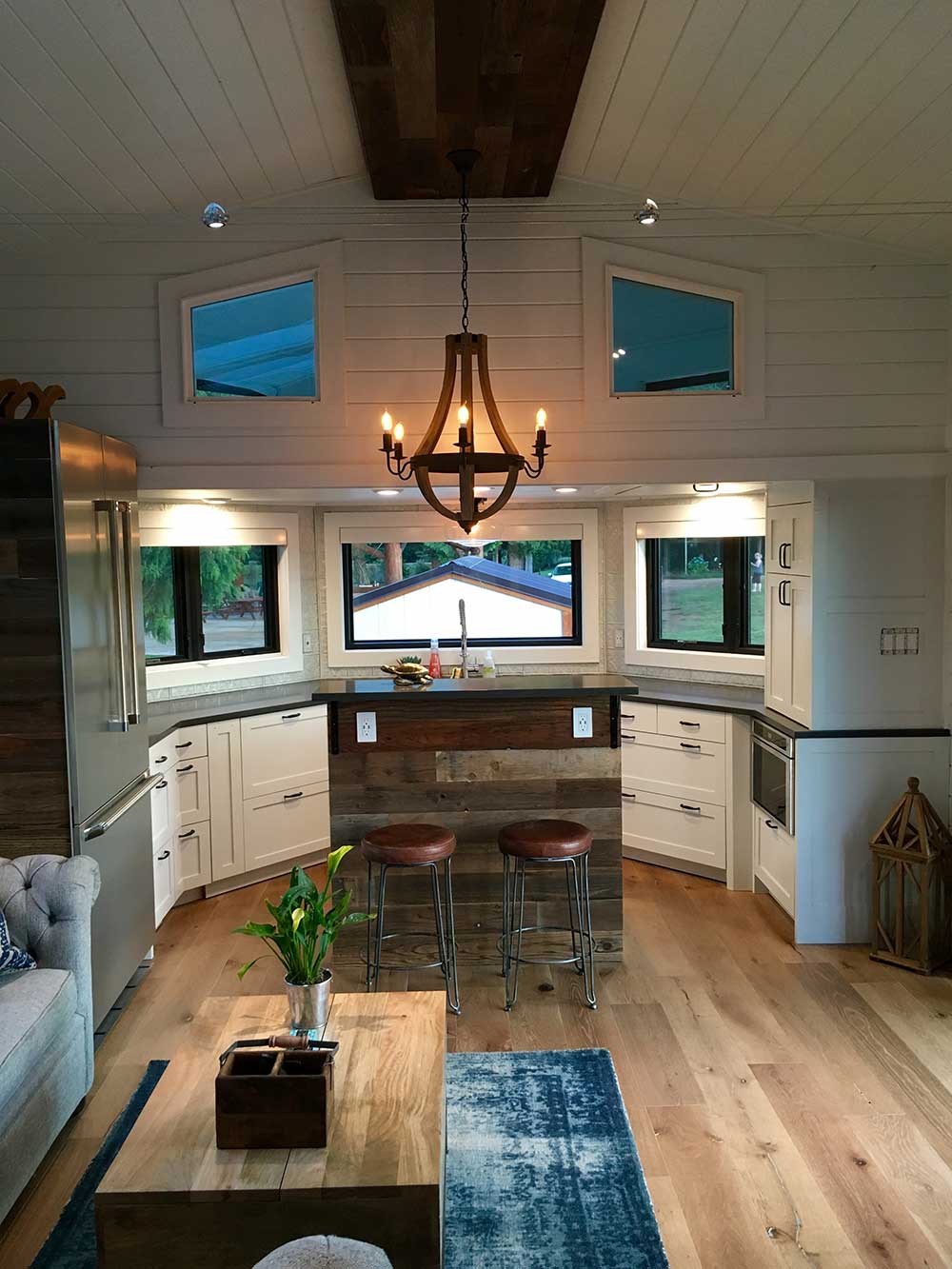 Interior of the Hawaiian Retreat custom tiny home showoing built in storage units and kitchen