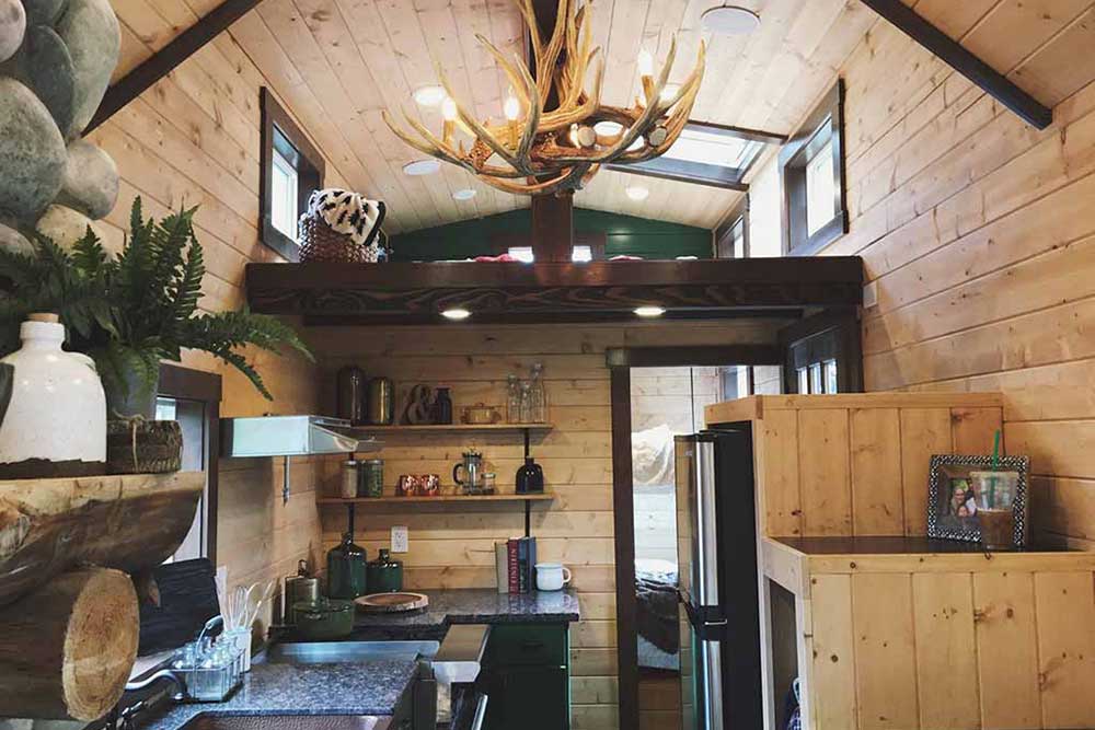 Interior of Tiny Rustic Cabin custom tiny home showing loft and kitchen