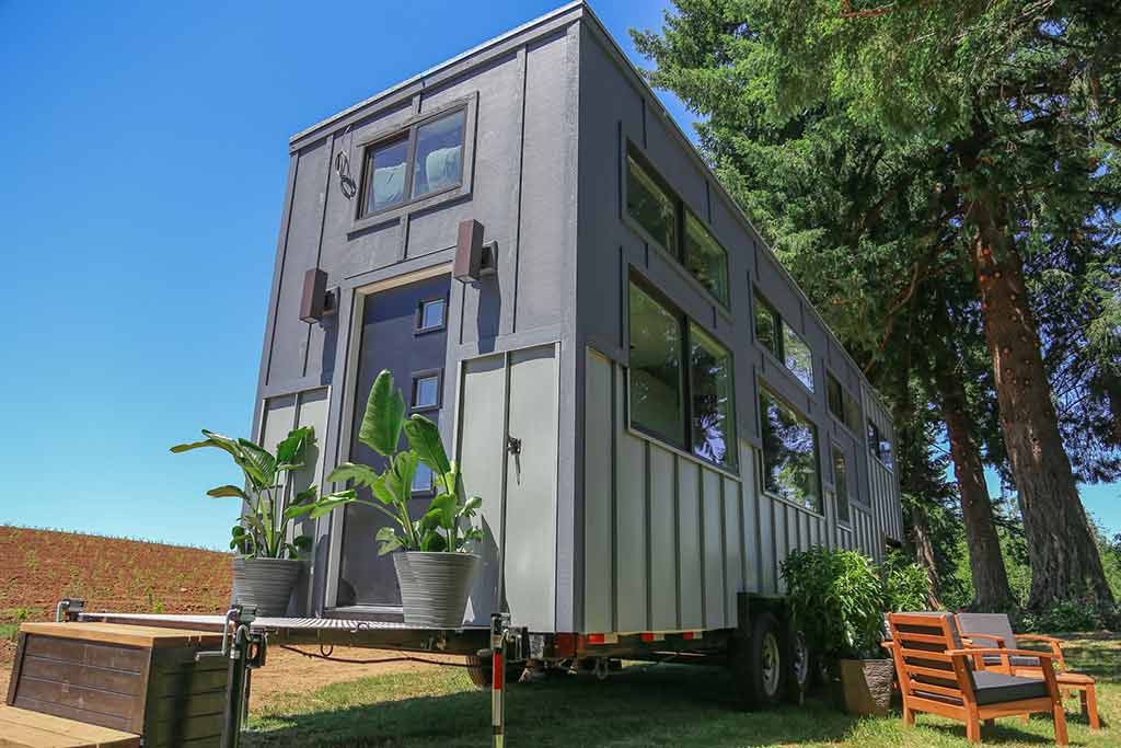 The Ultra Modern custom tiny home outside back view with potted plants